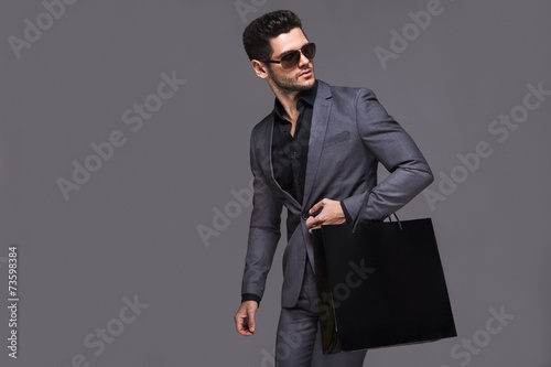 Handsome man in suit with shopping bag