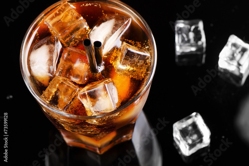 A full glass of cola with ice cubes