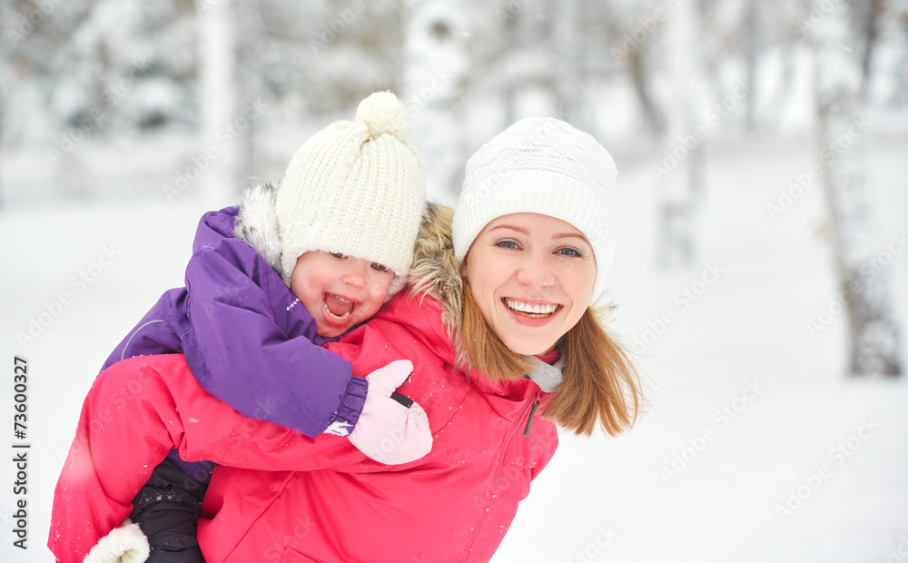 happy family mother and baby girl daughter playing  in winter