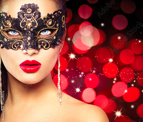 Woman wearing carnival mask over glowing red background