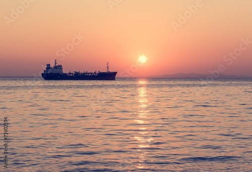 Cargo ship with setting sun © anzebizjan