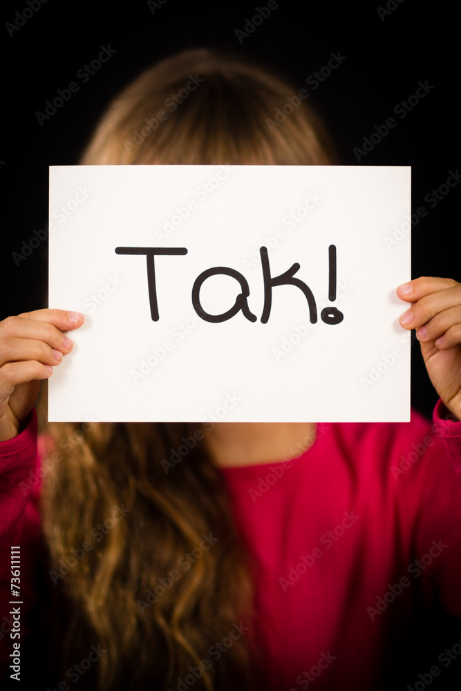 Child holding sign with Danish word Tak - Thank You Child holding sign with Danish word Tak - Thank You