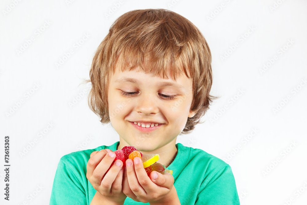 Little boy with sweets and candies on a white background Little boy with sweets and candies on a white background