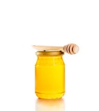 honey jar on white background with wooden honey dipper