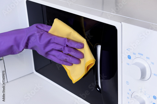 Cleaning microwave oven in kitchen close-up