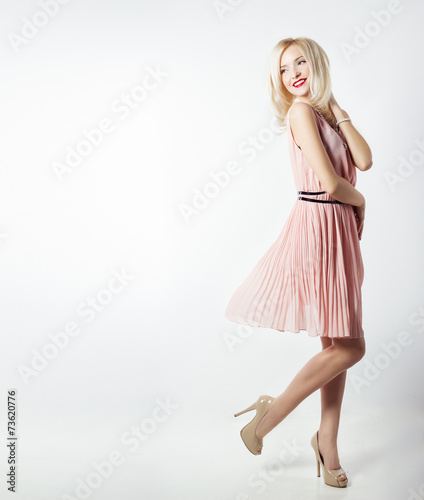 beautiful woman with bright makeup in pink dress with long legs