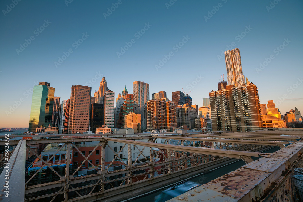 Obraz premium Lower Manhattan through Brooklyn Bridge at sunset, New York City