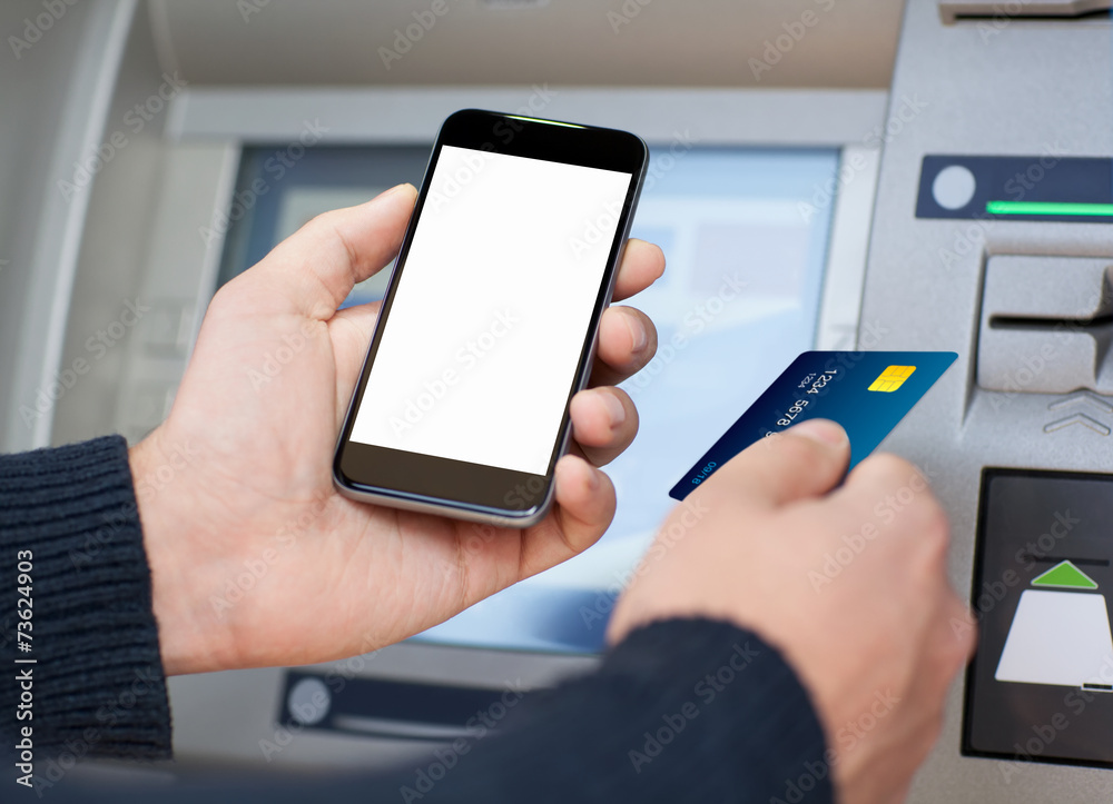 man holding phone and a credit card at an ATM man holding phone and a credit card at an ATM
