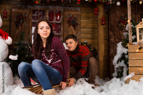 Couple with Sled Outdoors in Winter at Cabin