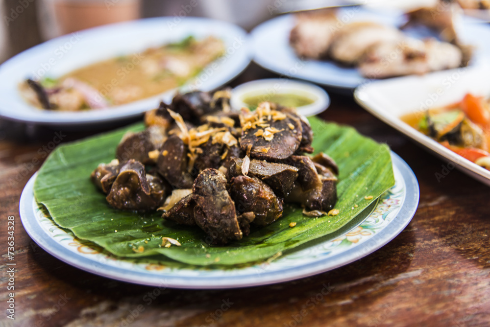 Chicken liver fried with garlic on banana leaf Chicken liver fried with garlic on banana leaf