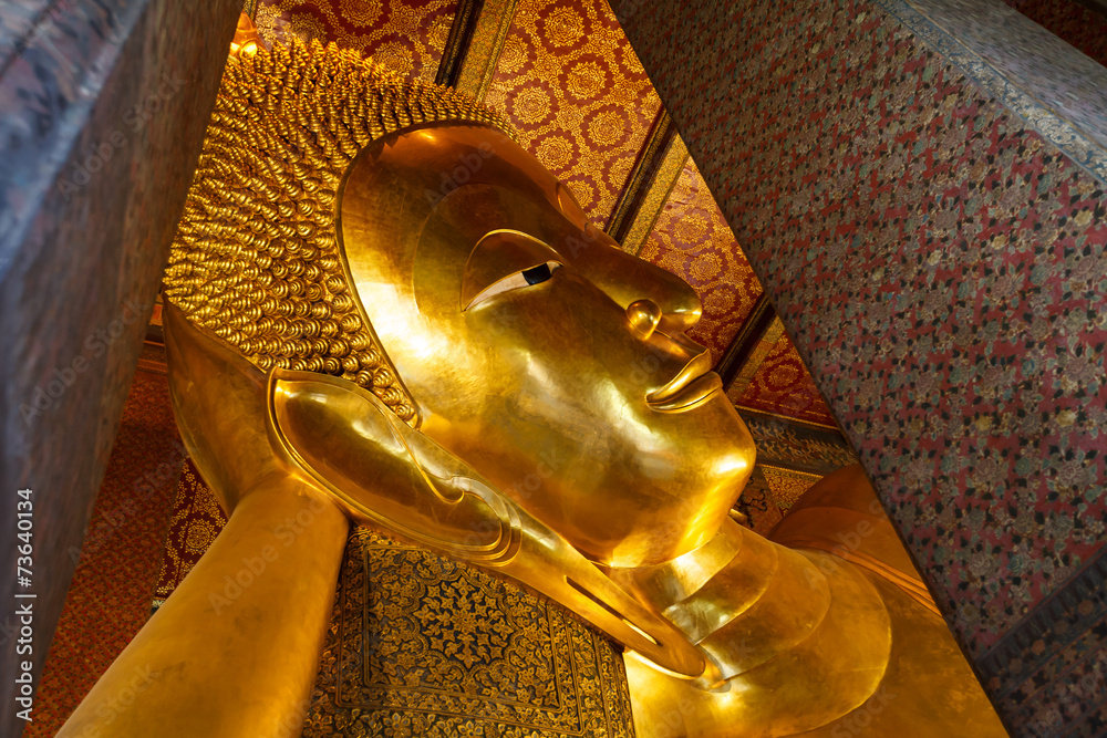 Reclining Buddha gold statue face. Wat Pho in Bangkok, Thailand