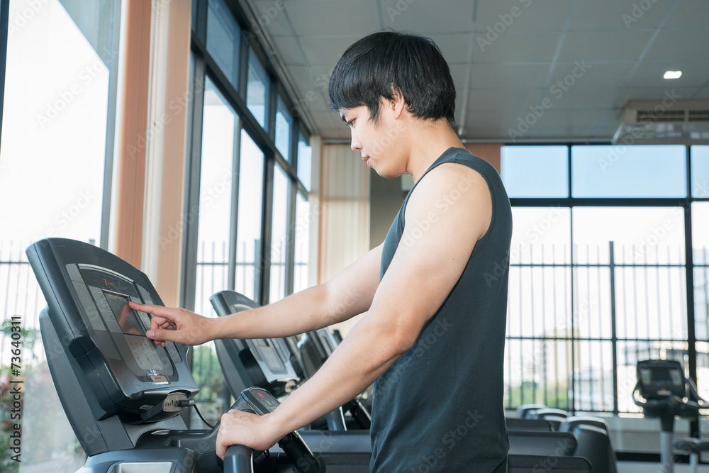 Man at the gym doing set up treadmill for fitness Man at the gym doing set up treadmill for fitness