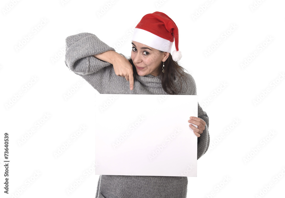 Latin woman in Santa Christmas hat pointing blank billboard
