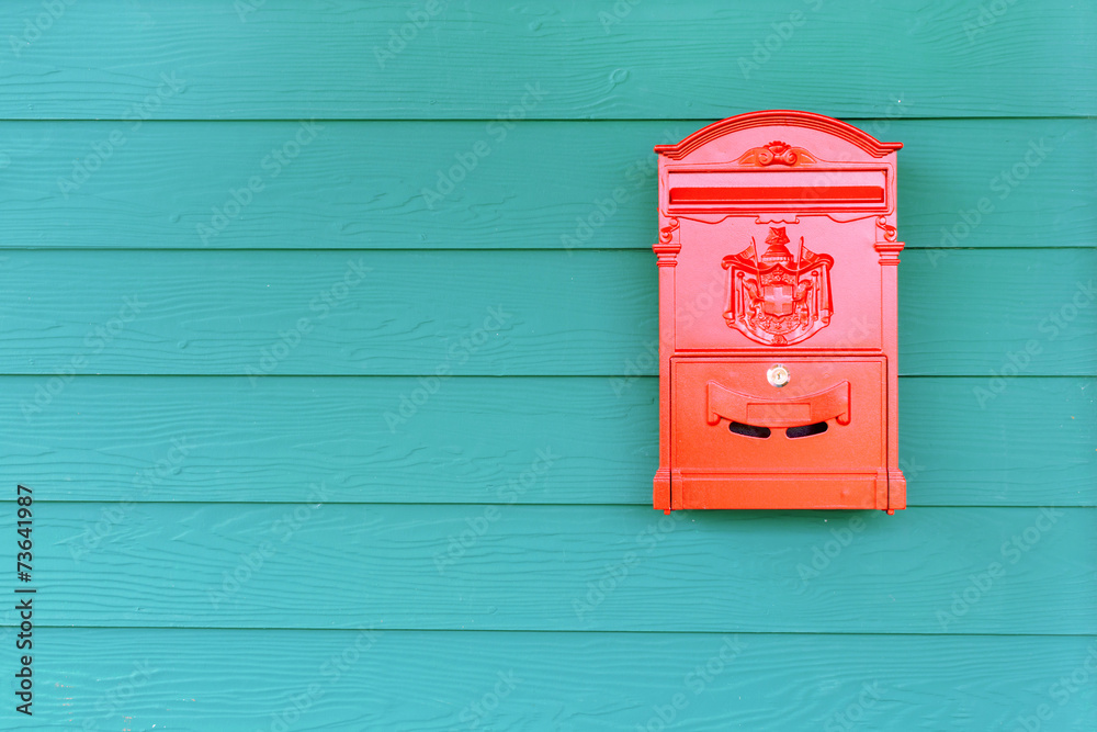 Red mailbox with green wood background