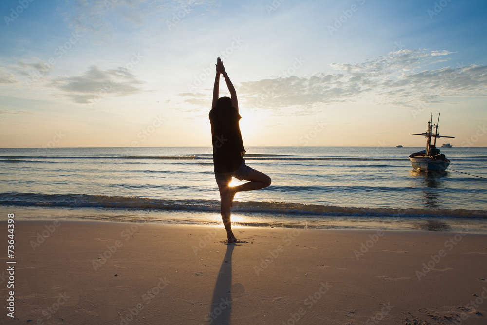 woman yoga on the beach at sunrise