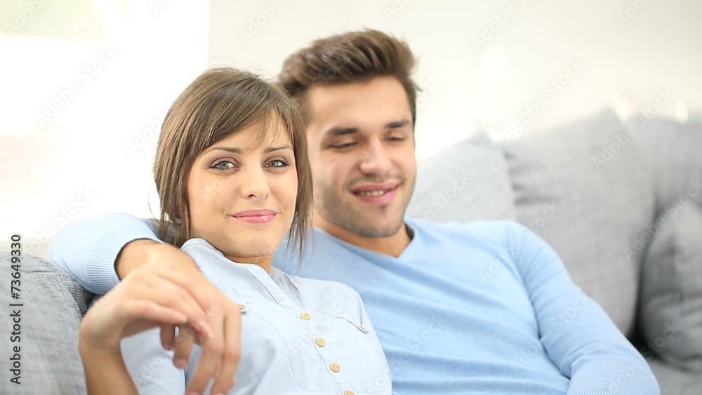 Young couple relaxing in sofa, looking at camera Young couple relaxing in sofa, looking at camera