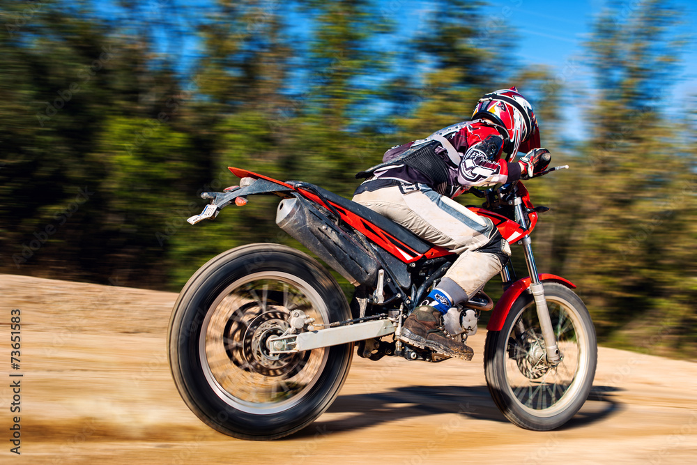 Teen boy riding Motocross bike on gravel road Teen boy riding Motocross bike on gravel road