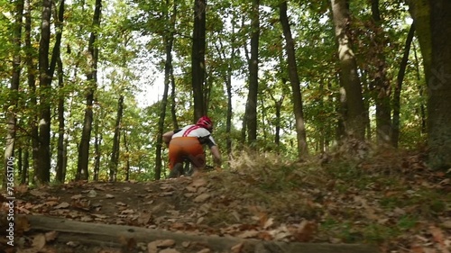 Young girl in helmet jumping on her mountain bicycle slow motion