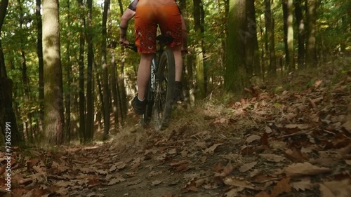 Young girl in helmet riding fast on her mountain bicycle slow