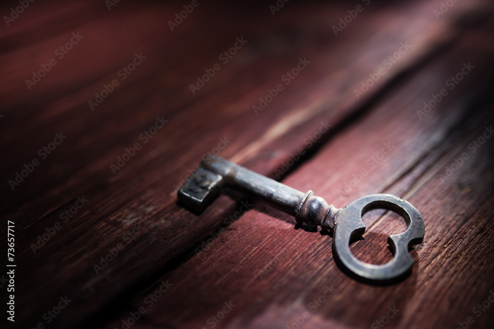 Rusty key on old wooden surface Rusty key on old wooden surface