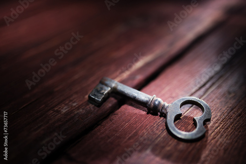 Rusty key on old wooden surface