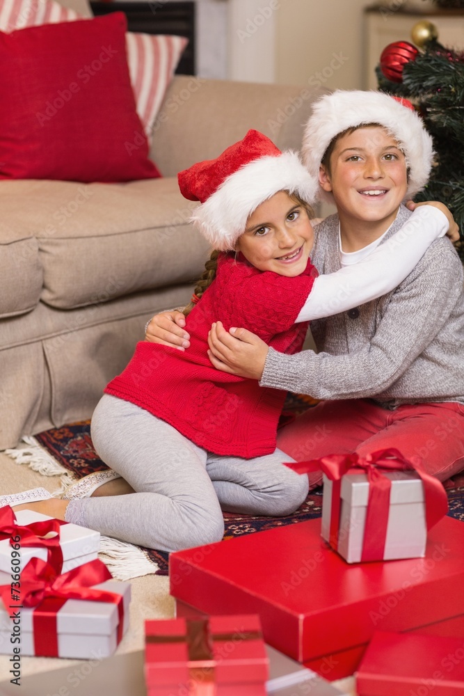 Brother and sister hugging near gifts Brother and sister hugging near gifts