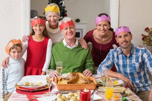 Happy extended family in party hat at dinner table