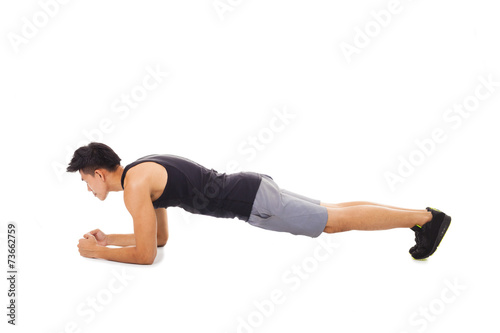 young fitness man doing plank core exercise working out