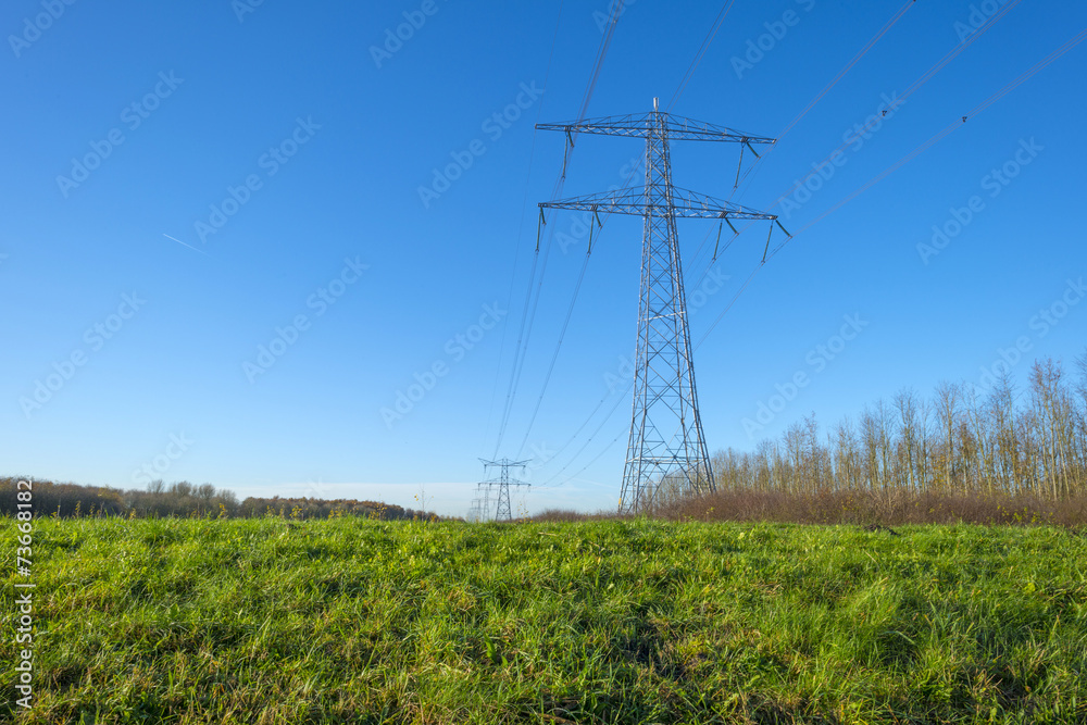 Transmission tower under a sunny sky at fall