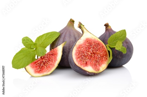 Four sliced figs isolated with mint on white background