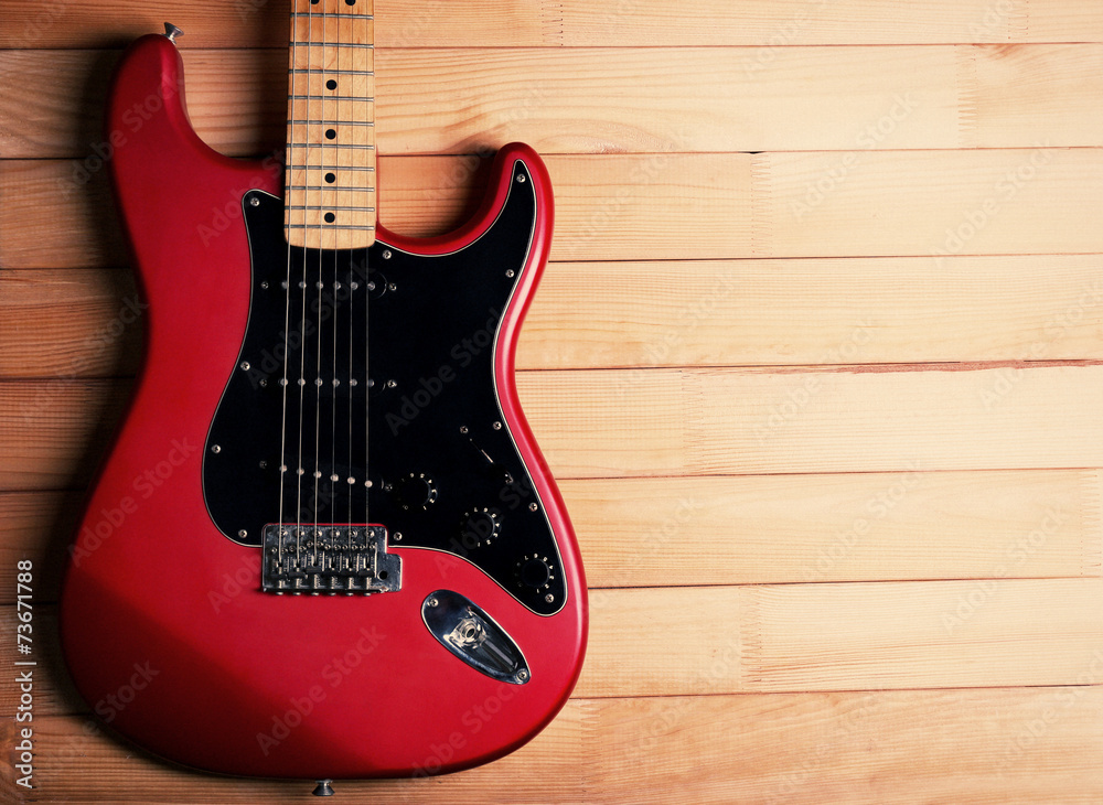 Fototapeta premium Red guitar on wooden background