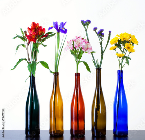 Fototapeta Naklejka Na Ścianę i Meble -  beautiful flowers in colorful bottles