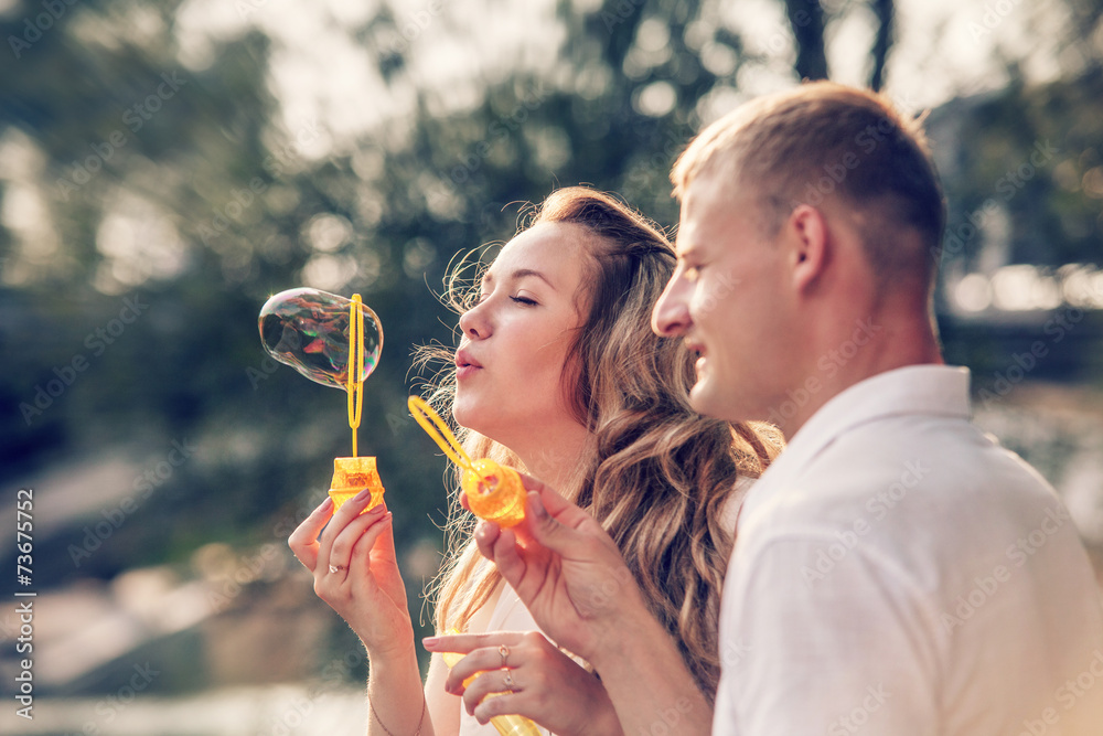 Fototapeta premium Young couple funny plaing with Soap bubbles