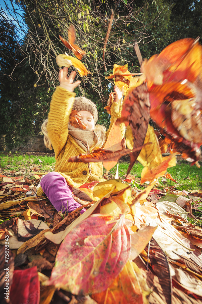 Beautiful girl, smiling blonde plays with the autumn leaves Beautiful girl, smiling blonde plays with the autumn leaves