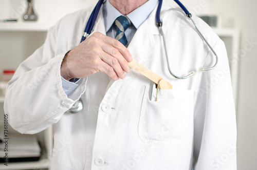 Doctor holding a medical mouth spatula