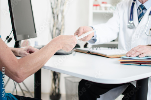 Doctor giving a prescription to his patient