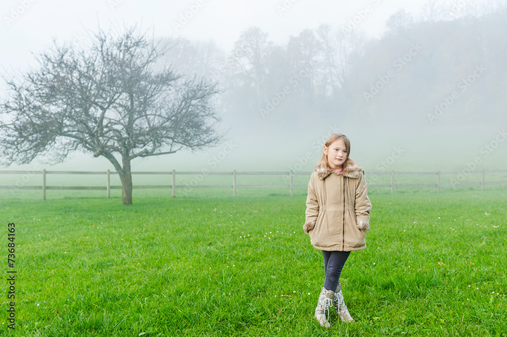 Outdoor portrait of a cute little girl on a foggy day