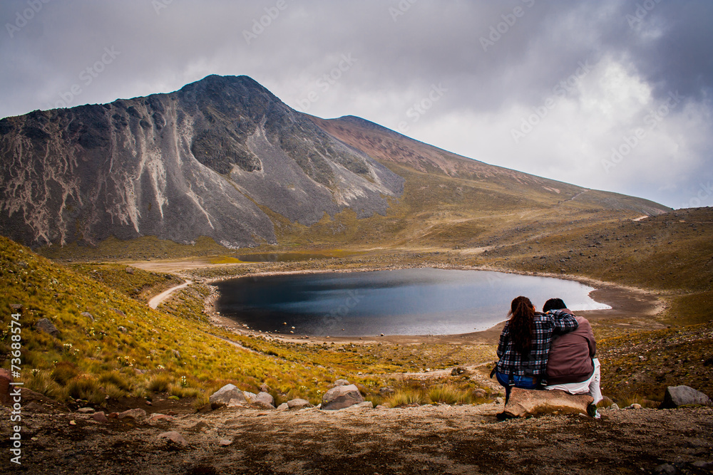 Couple hugging watching the mountain and lake