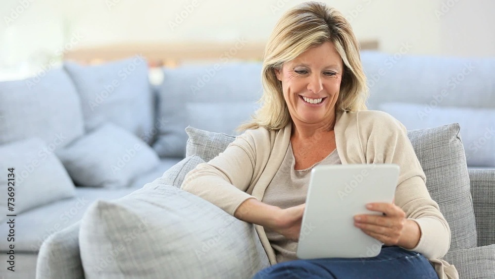 Mature woman websurfing on internet with tablet Mature woman websurfing on internet with tablet