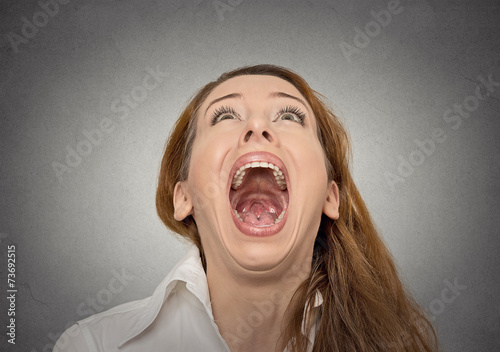 Headshot screaming woman with wide open mouth looking up photo