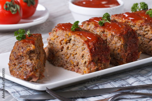 Sliced meat loaf with ketchup and parsley close-up