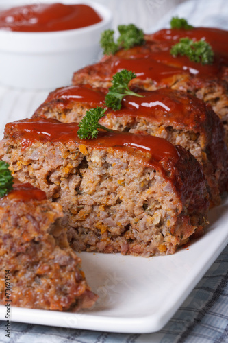 sliced meat loaf with ketchup and parsley close-up