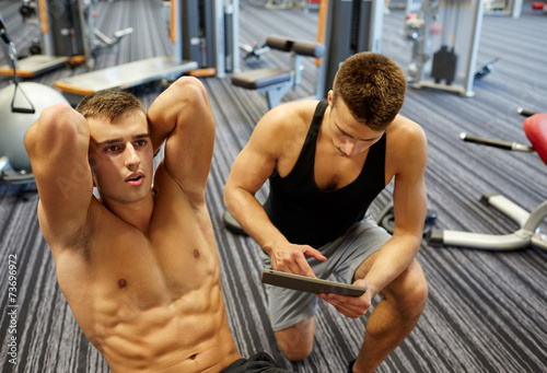 men flexing abdominal muscles in gym