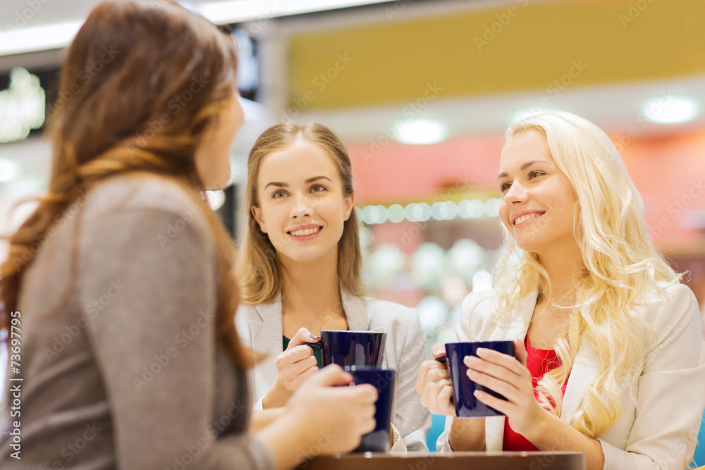 smiling young women with cups in mall or cafe smiling young women with cups in mall or cafe