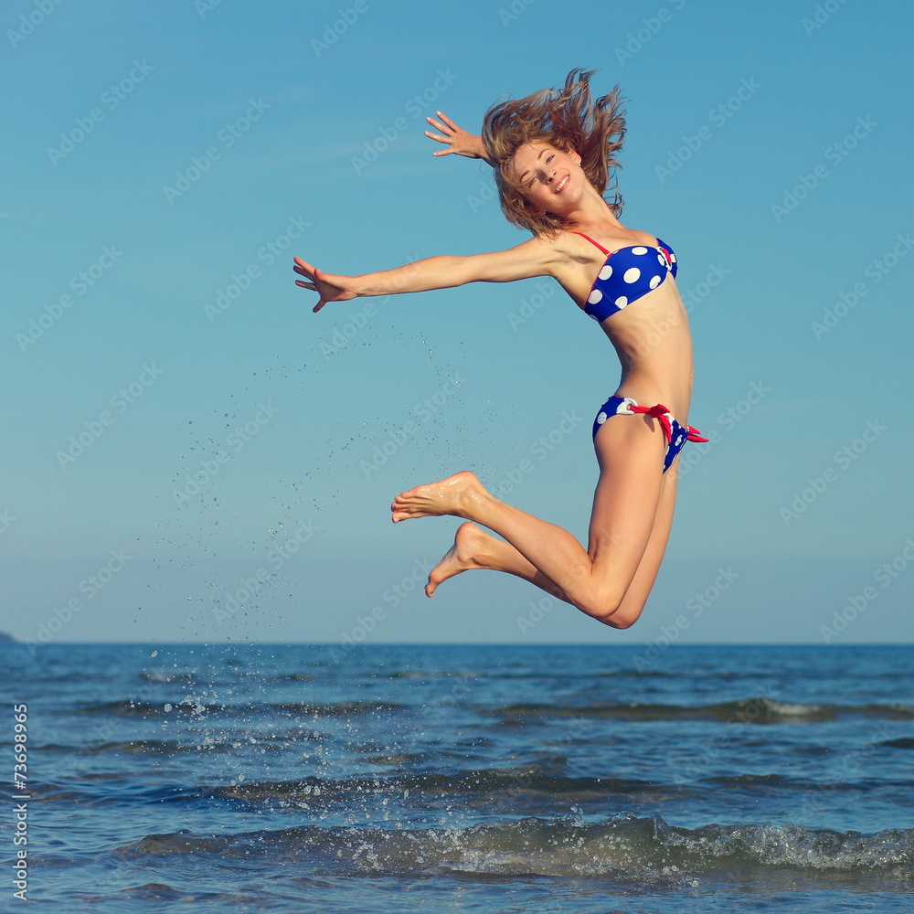 cheerful girl jumping at sea