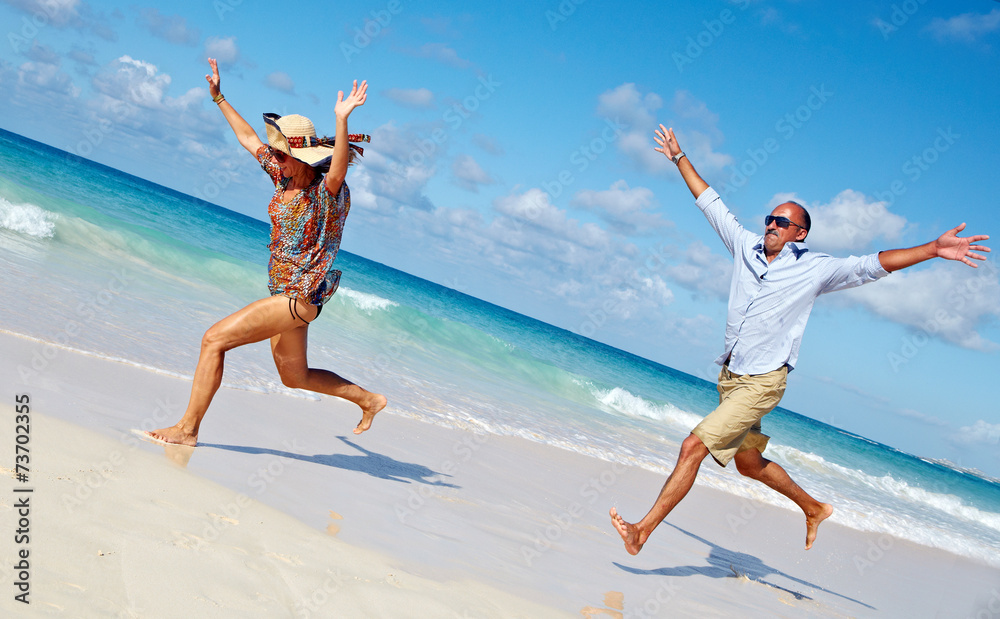 Happy couple running on the beach.