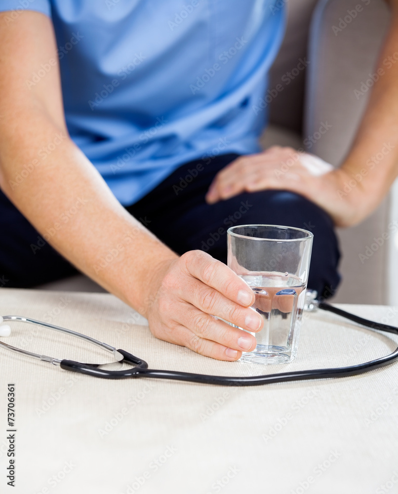 Male Caretaker Holding Glass Of Water