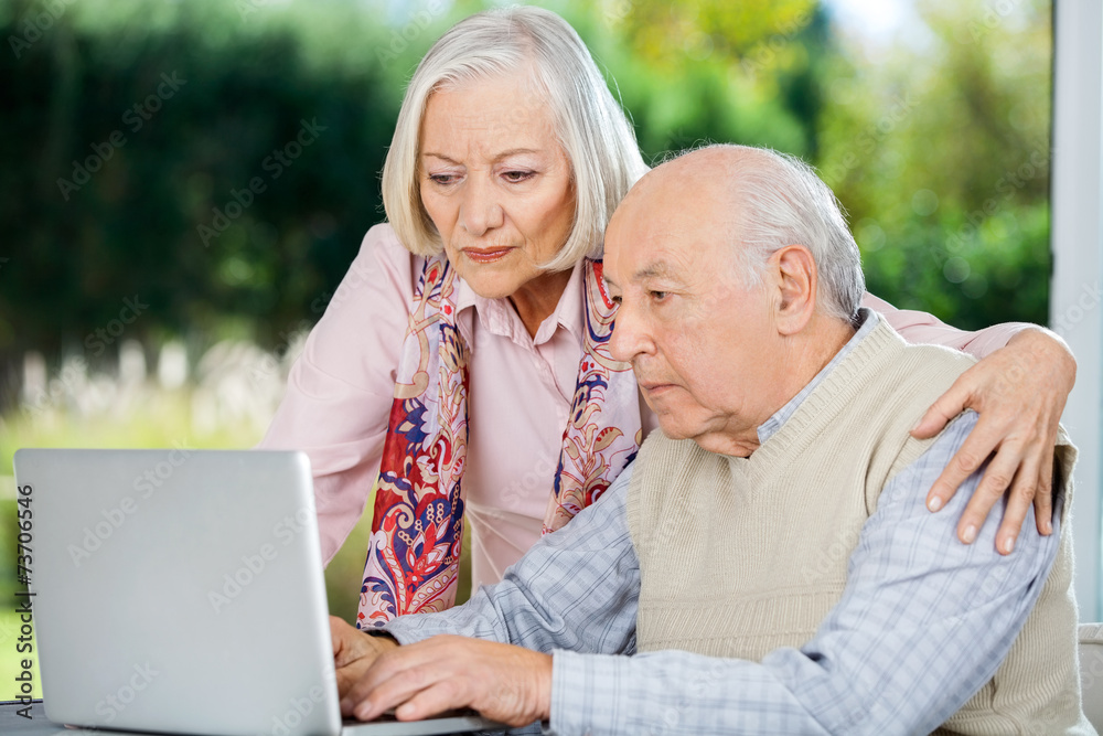 Serious Senior Man And Woman Using Laptop Serious Senior Man And Woman Using Laptop