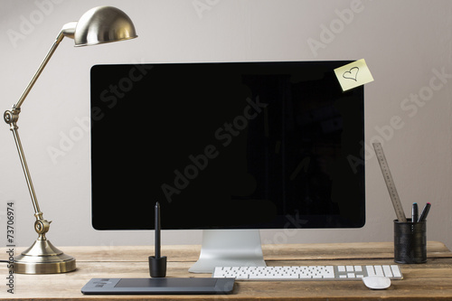big computer screen with stationary items