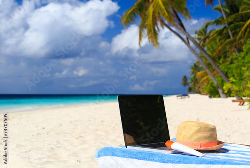 Fototapeta Naklejka Na Ścianę i Meble -  laptop on chair in tropical beach vacation
